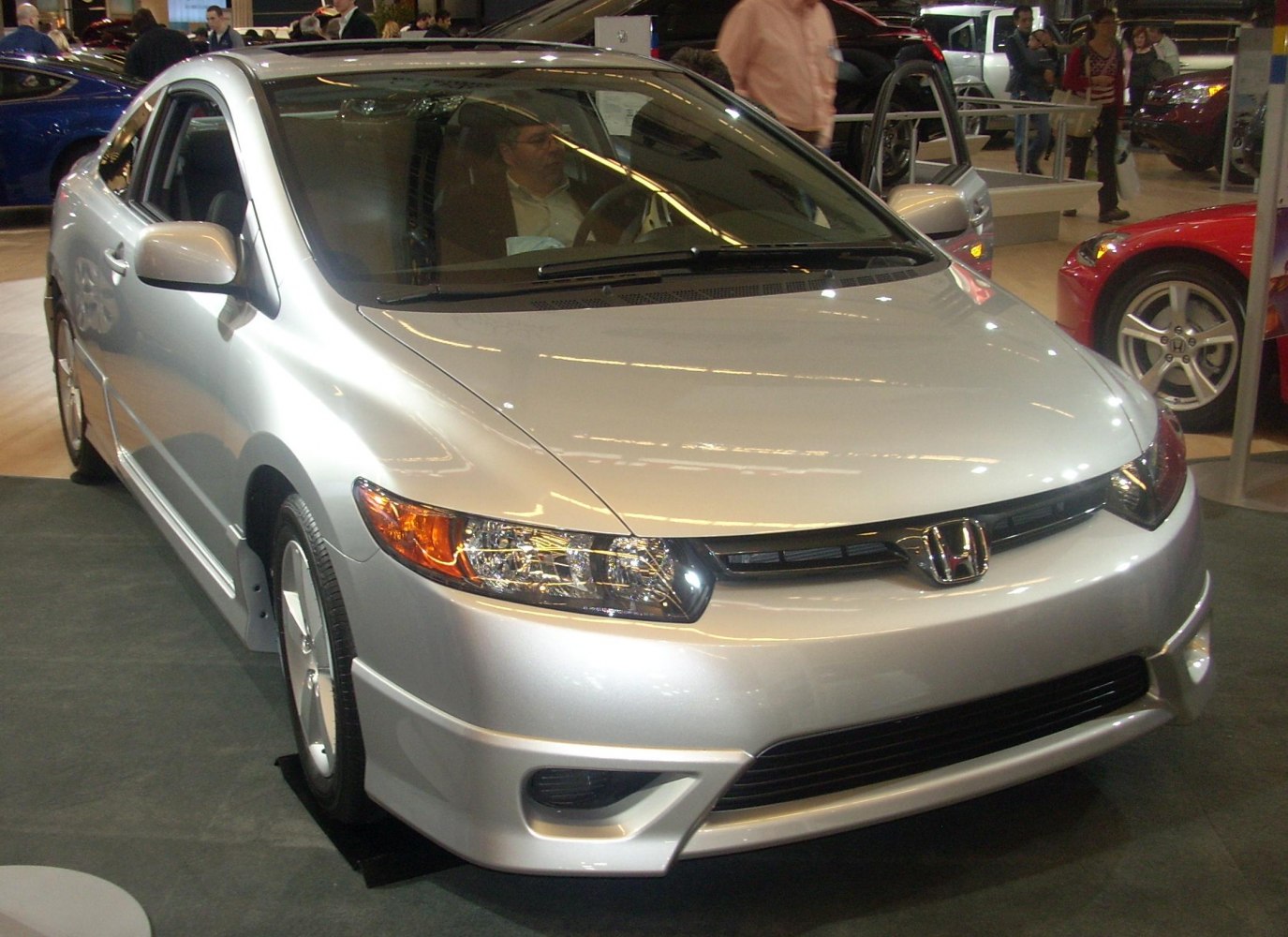 Front angle view of a silver two-door coupe with clear headlamps