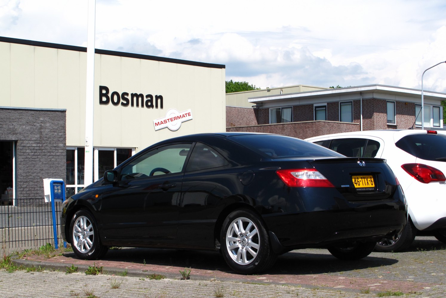 Rear and side profile of black coupe with alloy wheels and distinctive rear lights