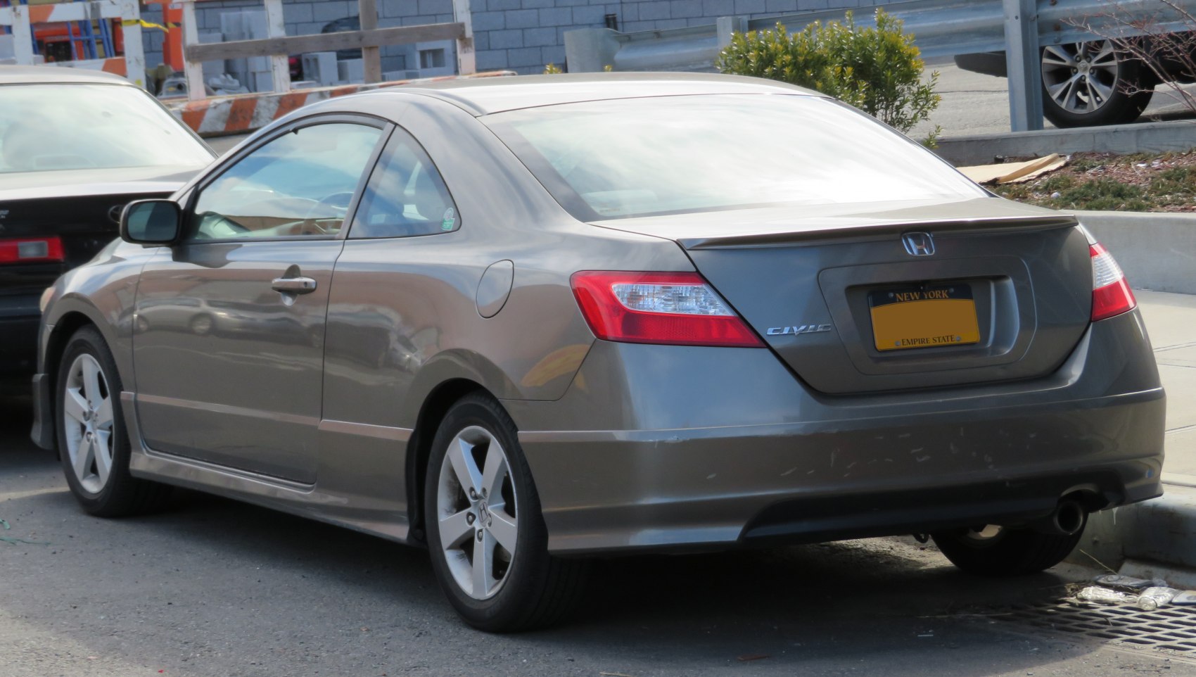 Rear and side profile of a coupe with alloy wheels and distinct taillights