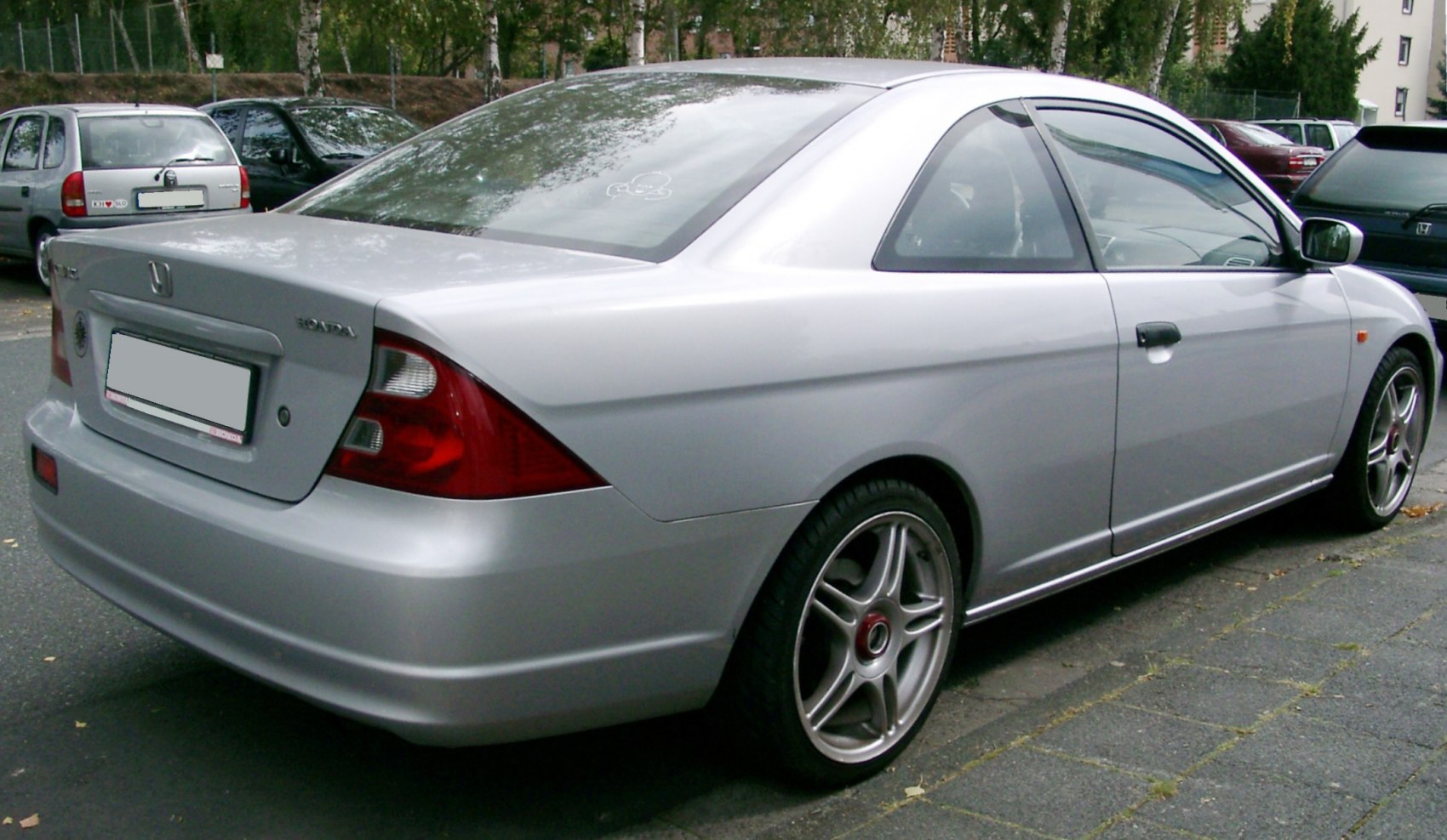Silver two-door coupe with distinctive tail lights and alloy wheels