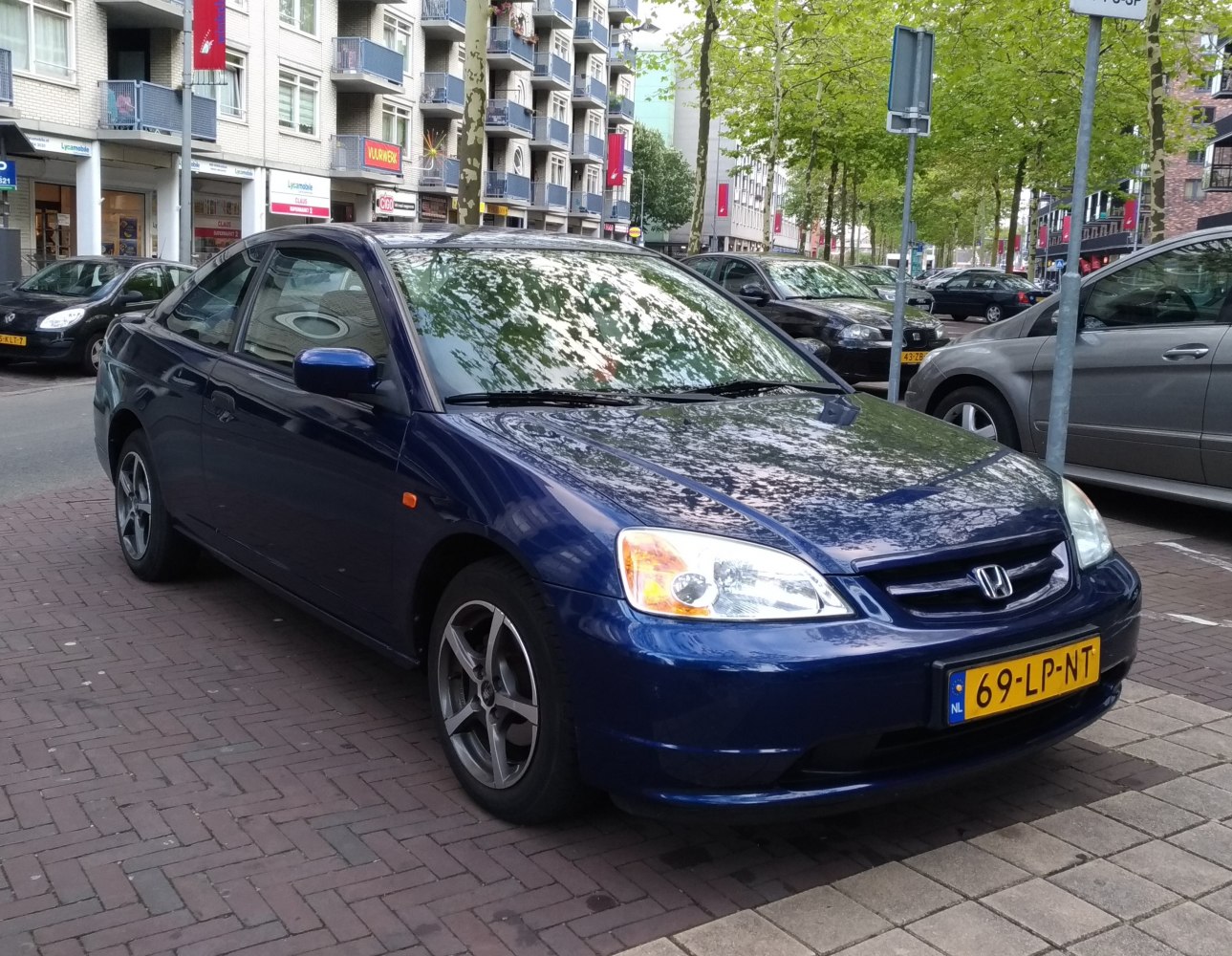 Front-side view of a compact coupe with alloy wheels and distinct headlights.