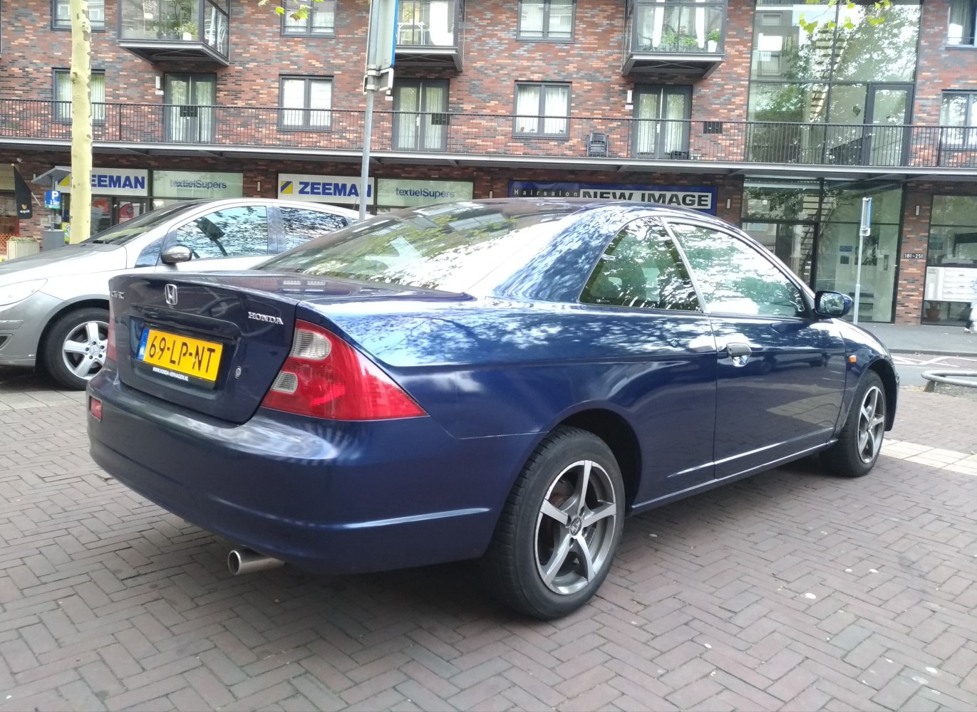 Rear and side view of a two-door coupe with distinctive tail lights and sporty profile