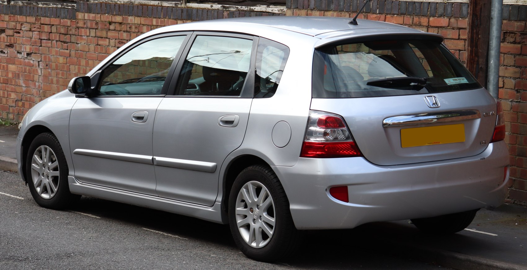 Rear side view of a silver 5-door hatchback with distinct tail lights and chrome rear trim