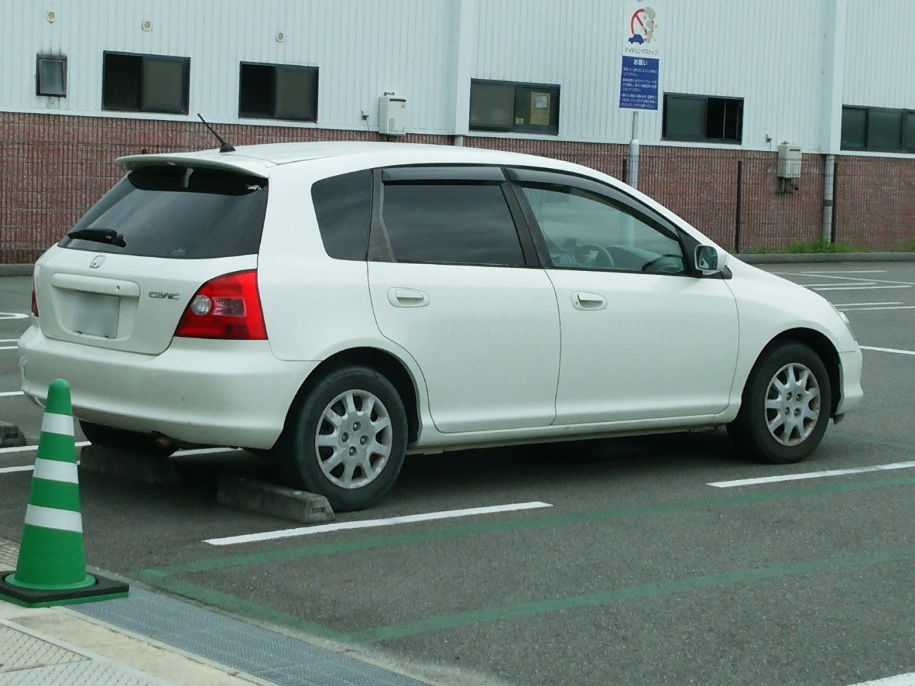White 5-door hatchback rear side view parked in urban lot