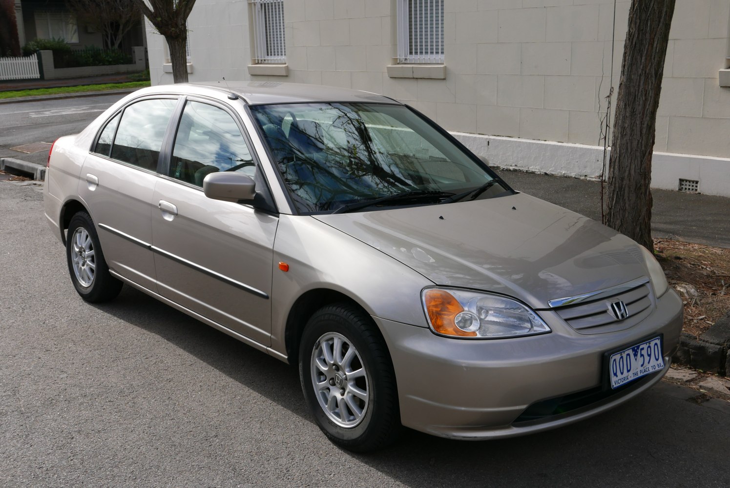 Front side view of silver compact sedan with alloy wheels and clear headlights