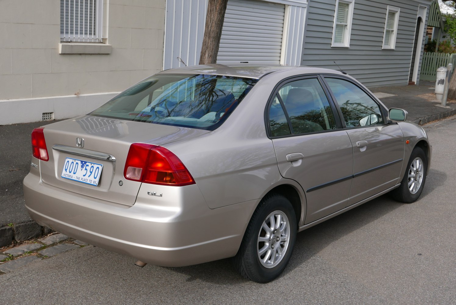 Compact sedan rear and side view with red taillights and silver paint.