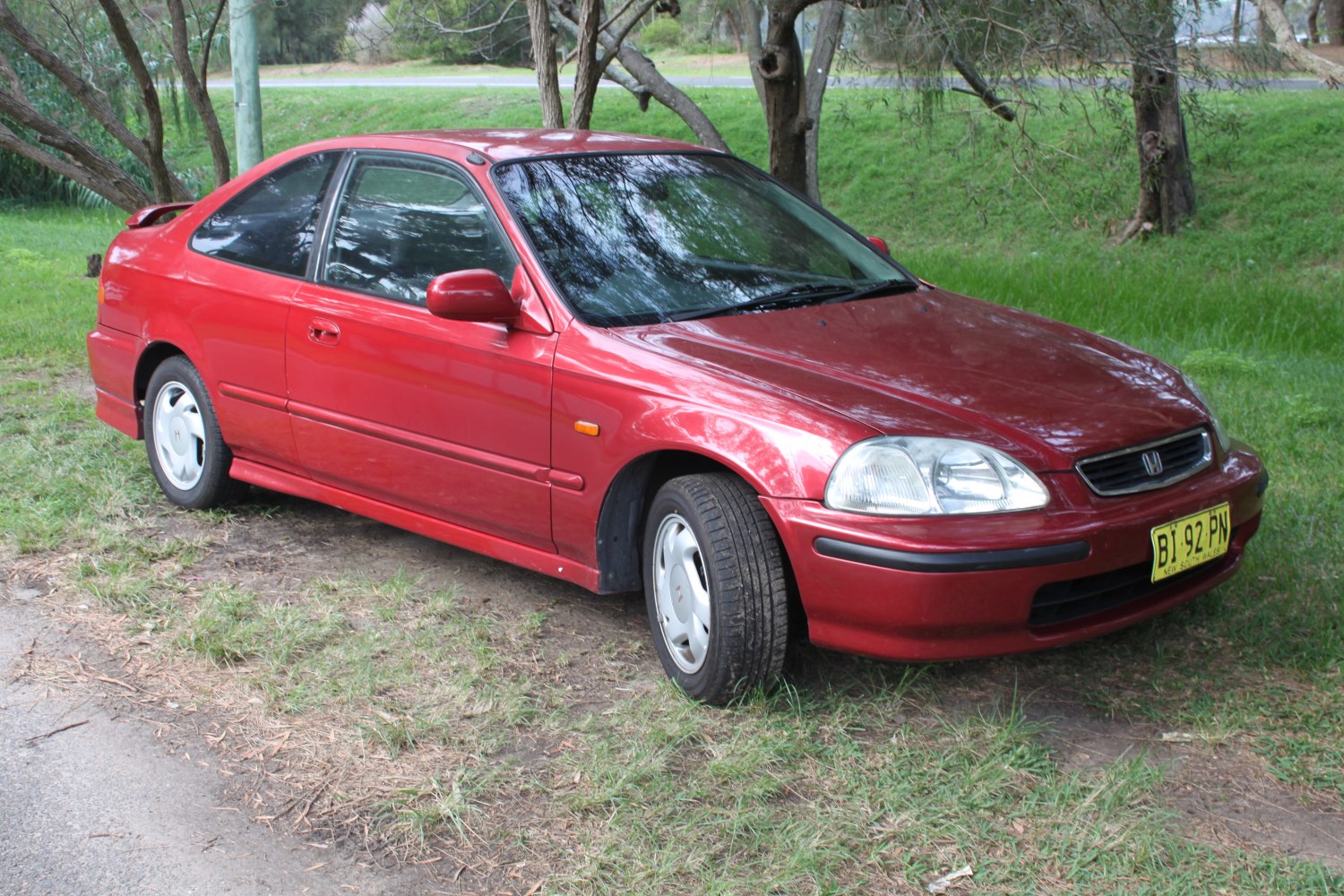 Red two-door coupe with aerodynamic styling and alloy wheels
