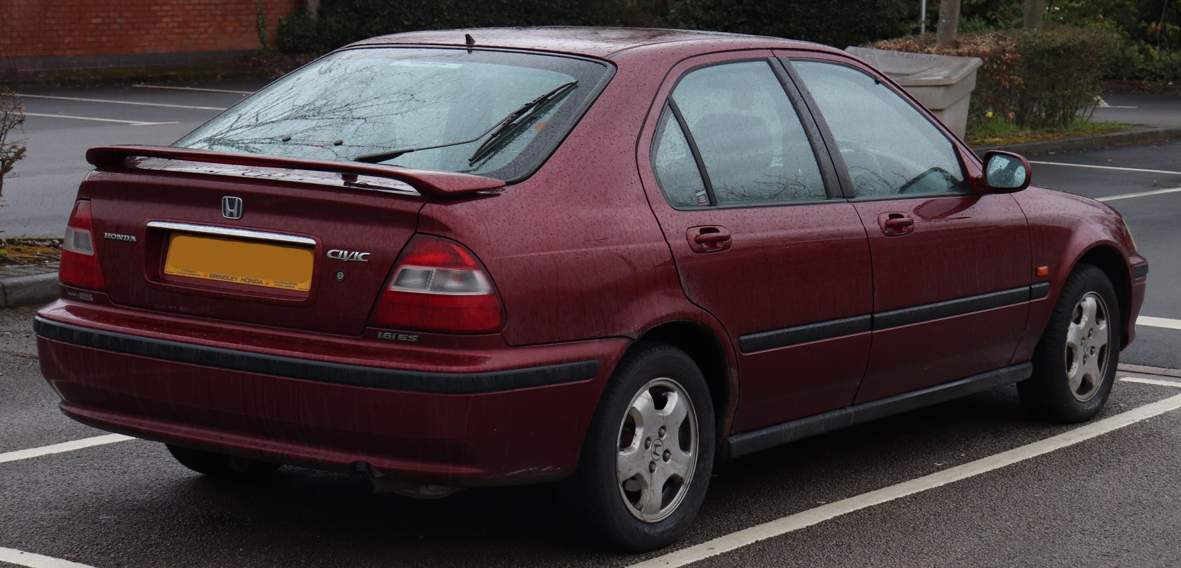 Rear side view of a hatchback showing rear spoiler and taillights