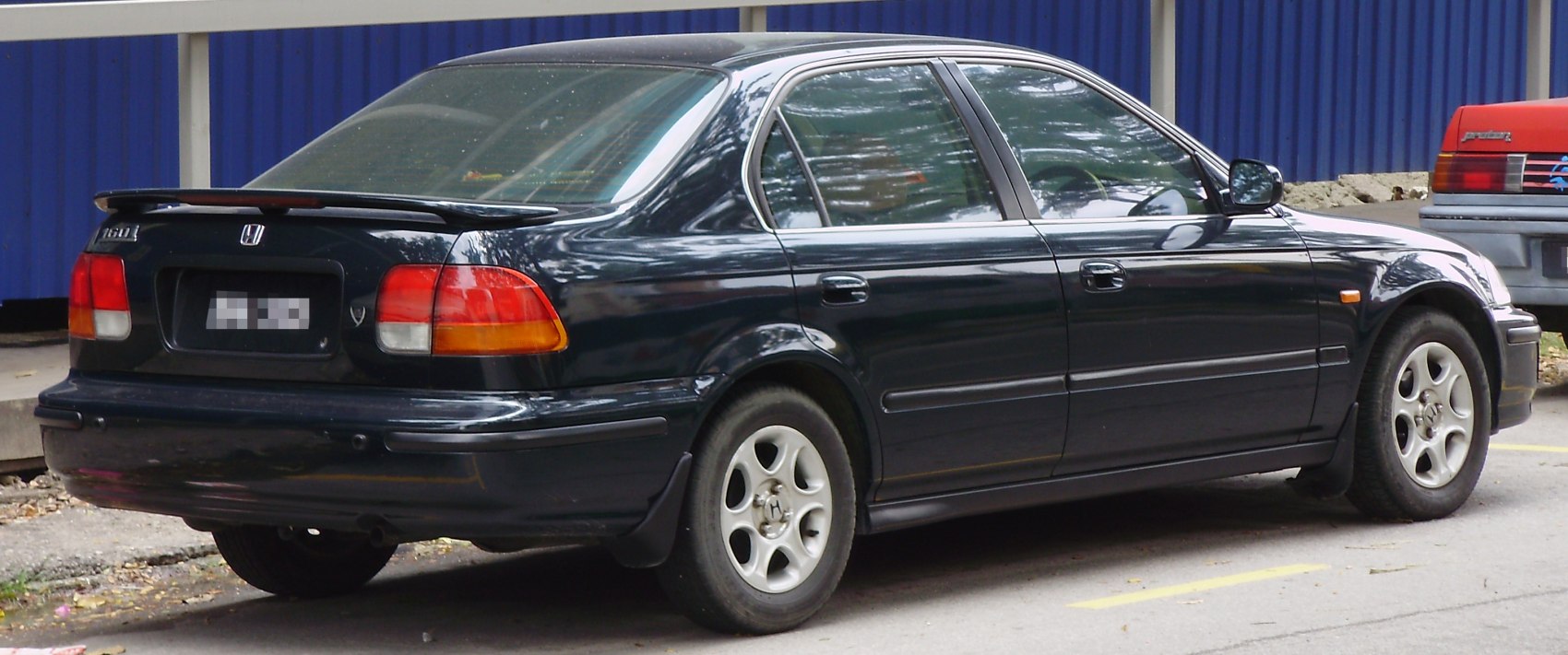 Black sedan rear and side view with spoiler and alloy wheels