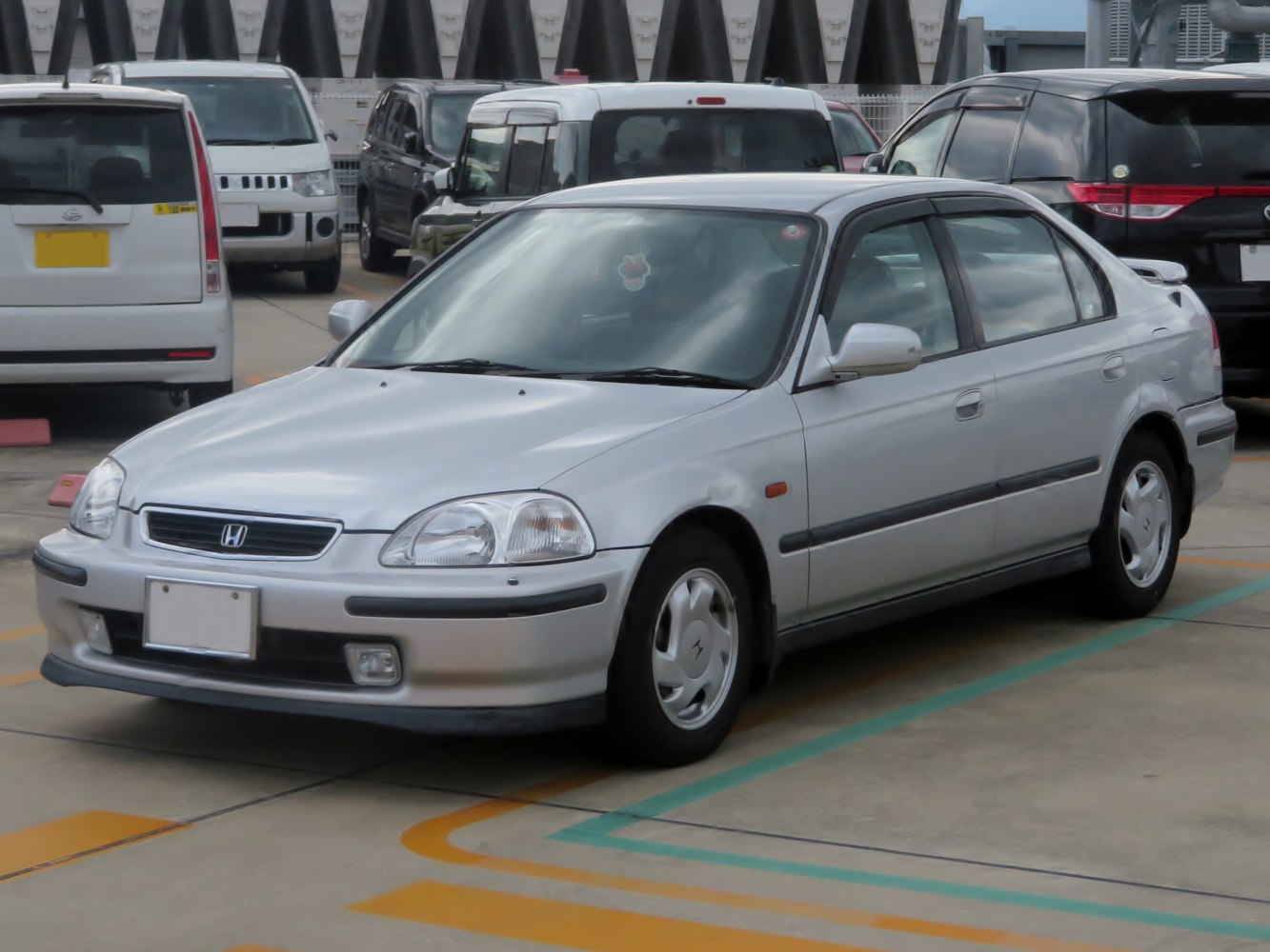 Silver mid-1990s sedan hatchback with clean lines and distinct headlights