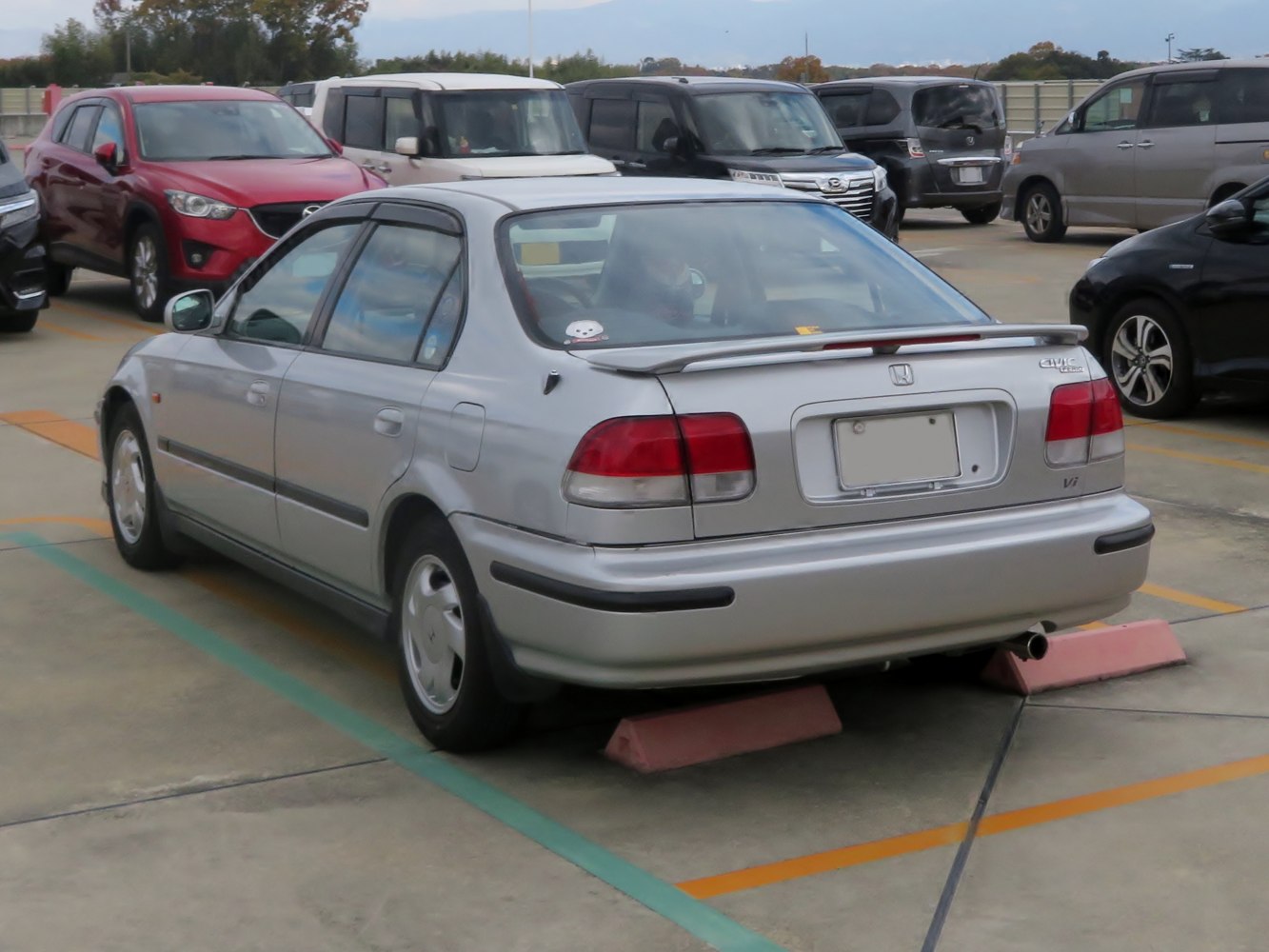 Rear sedan view with spoiler and classic taillights