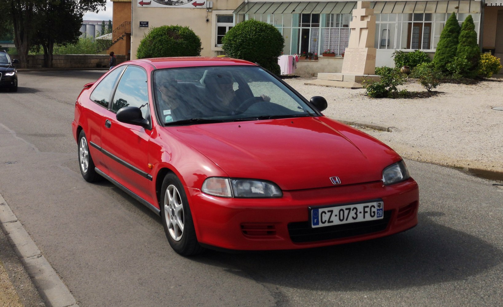 Red compact coupe with distinctive front and side profile