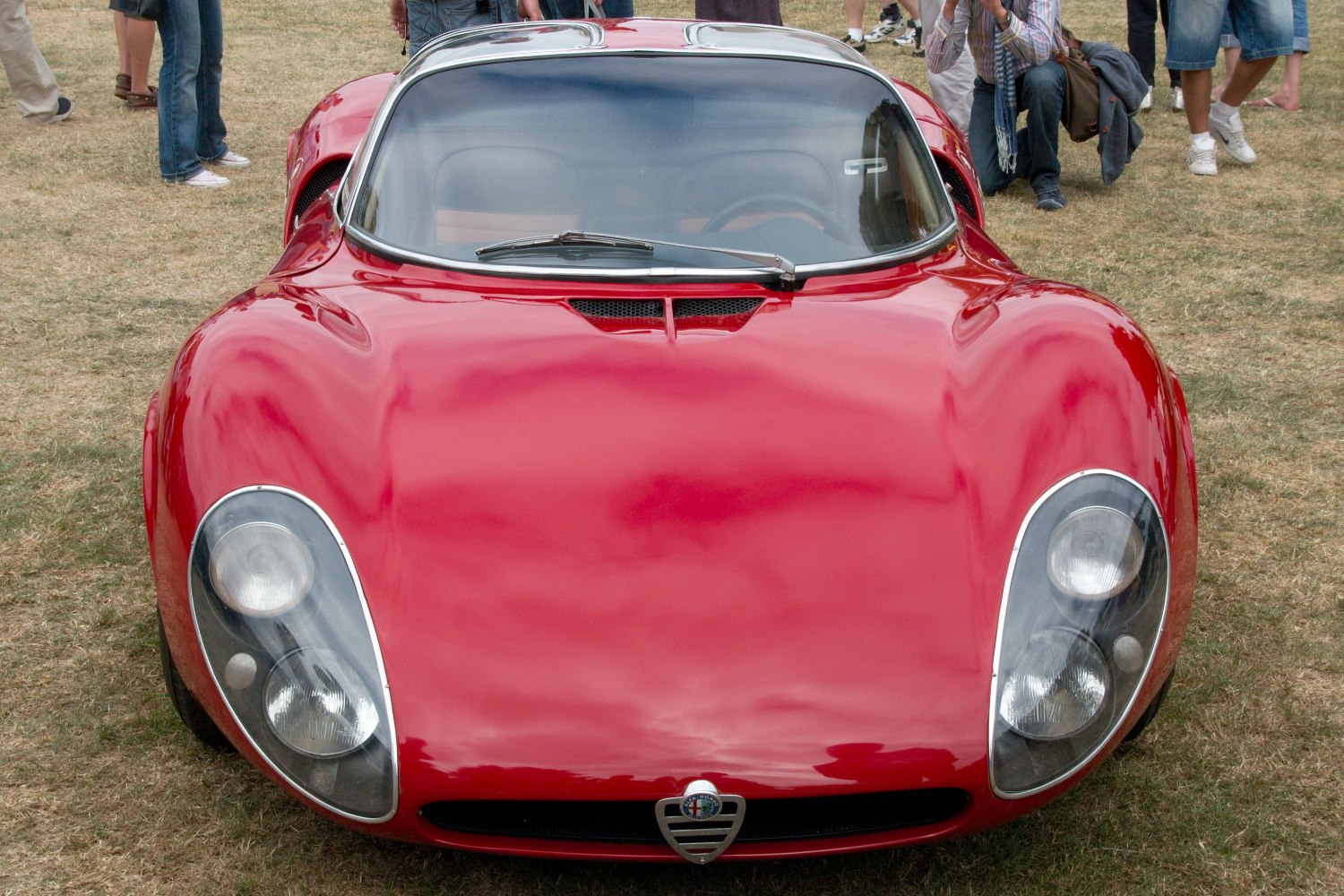 Front view with curved headlights and sleek glossy body in red