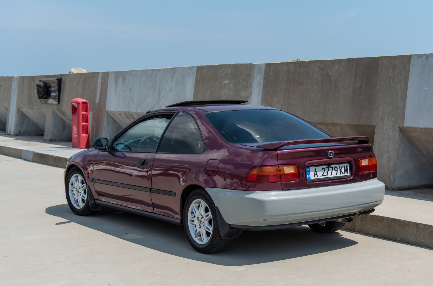 Rear 3-4 view showing car spoiler and alloy wheels