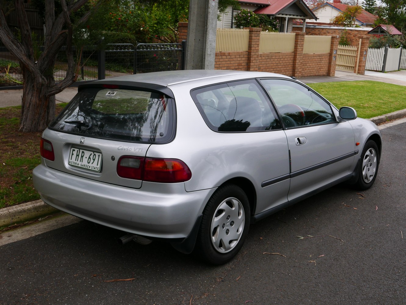 Silver 1991 compact hatchback rear-side view with distinct taillights and wheels