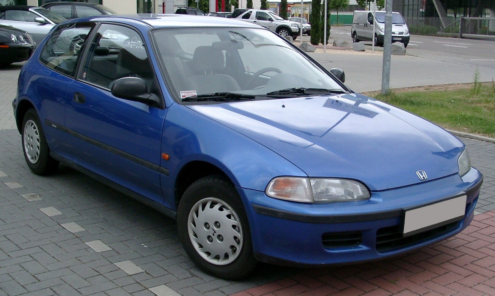 Blue three-door hatchback with classic 90s design.