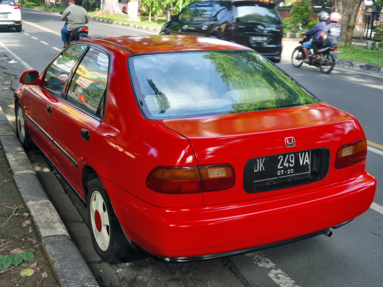 Red compact sedan with distinct rear design and tail lights.