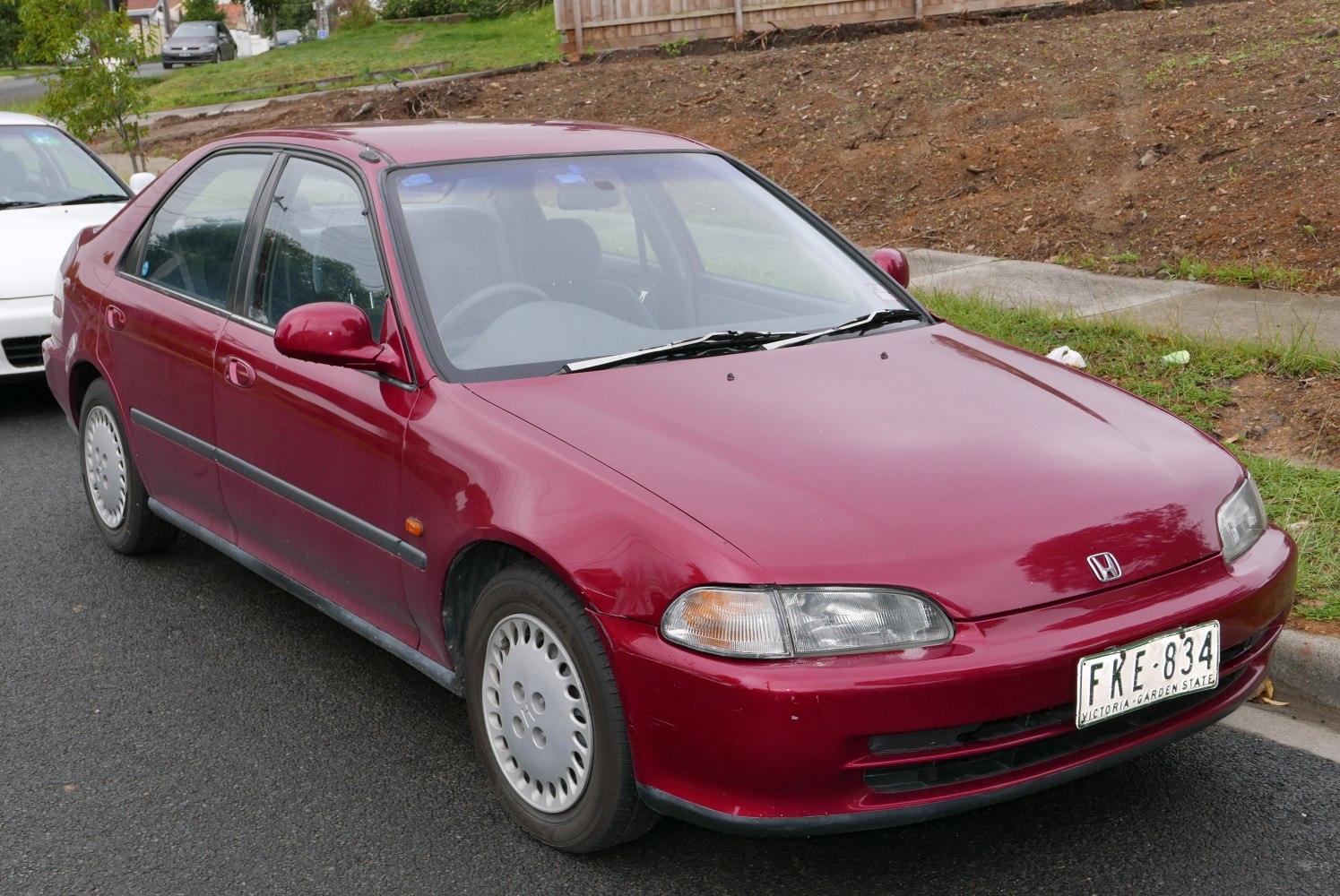 Red compact sedan with oval headlights and aerodynamic body