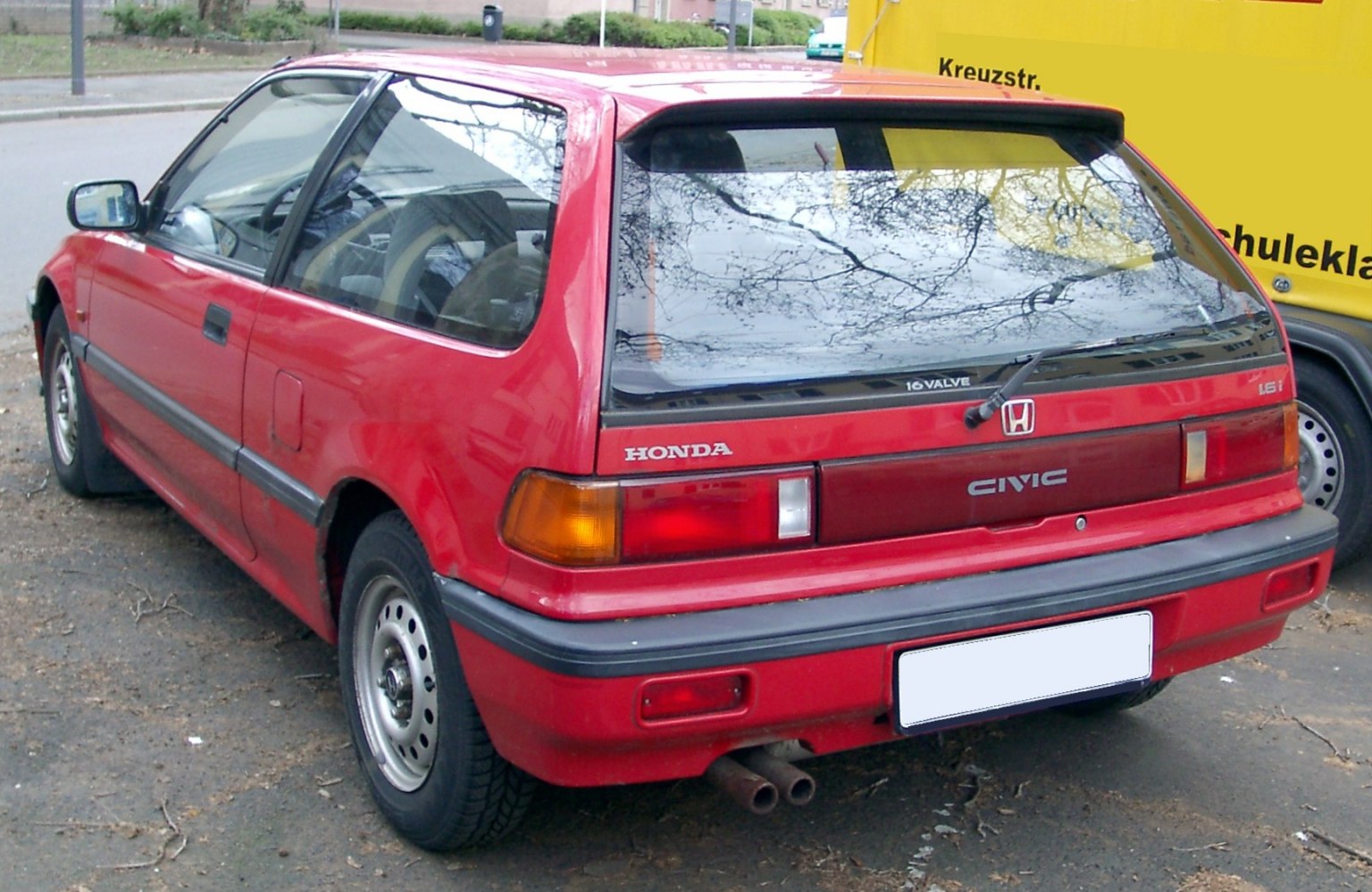 Rear side view of red hatchback with 16V badge and dual exhaust
