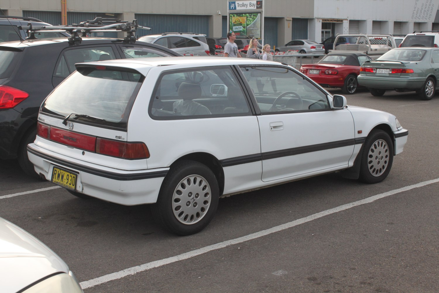 White hatchback rear three-quarter view with spoiler and rectangular taillights