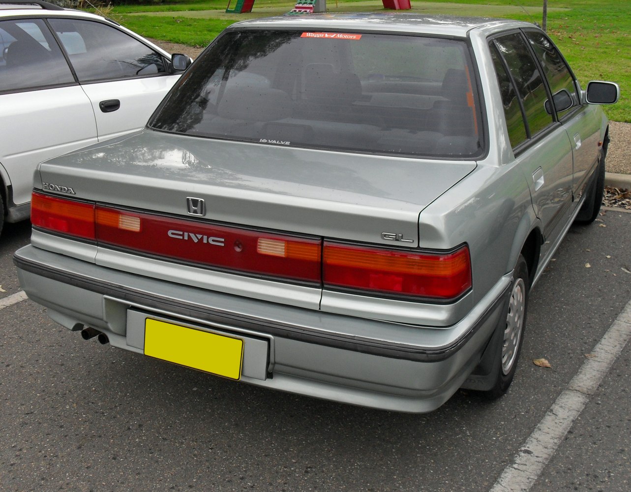Rear view of a classic sedan with vintage tail lights and rear panel.