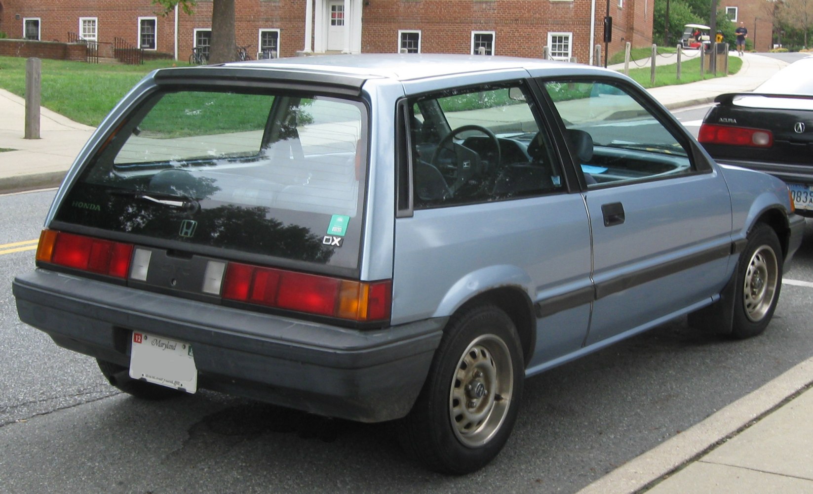 Rear view of vintage compact hatchback with steel wheels and distinctive tail lights