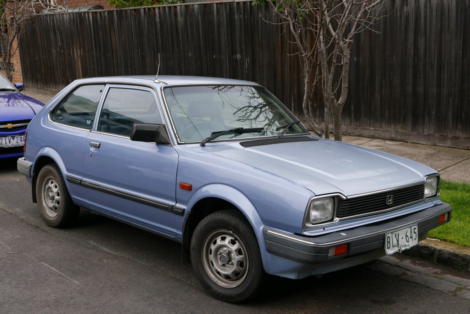 Compact hatchback with square headlights and steel wheels