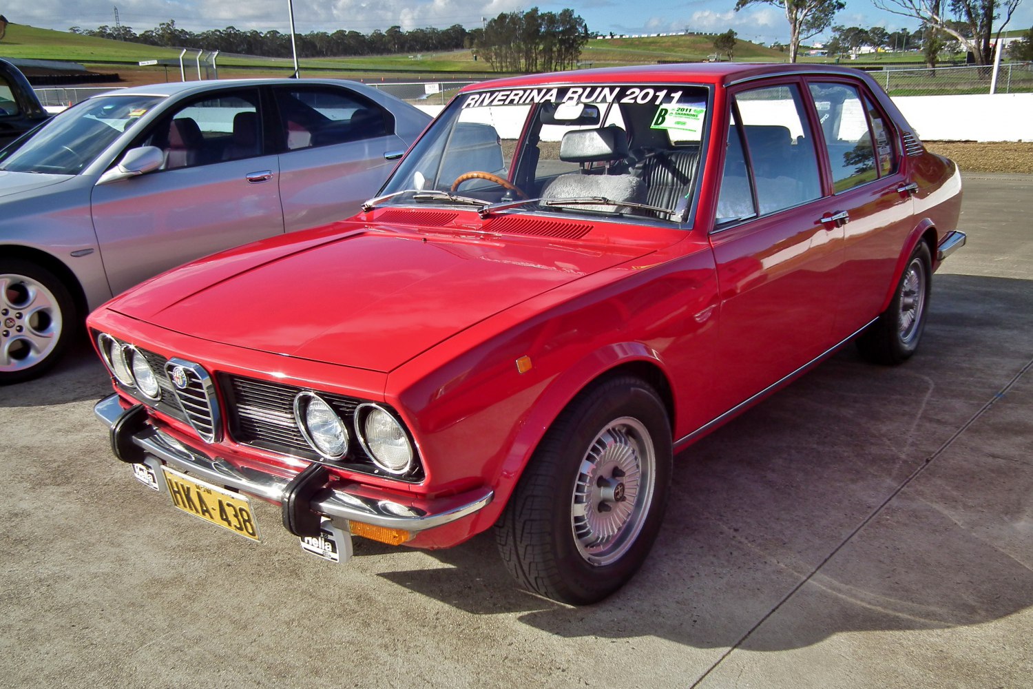 Vintage red sedan with quad round headlights and chrome bumper