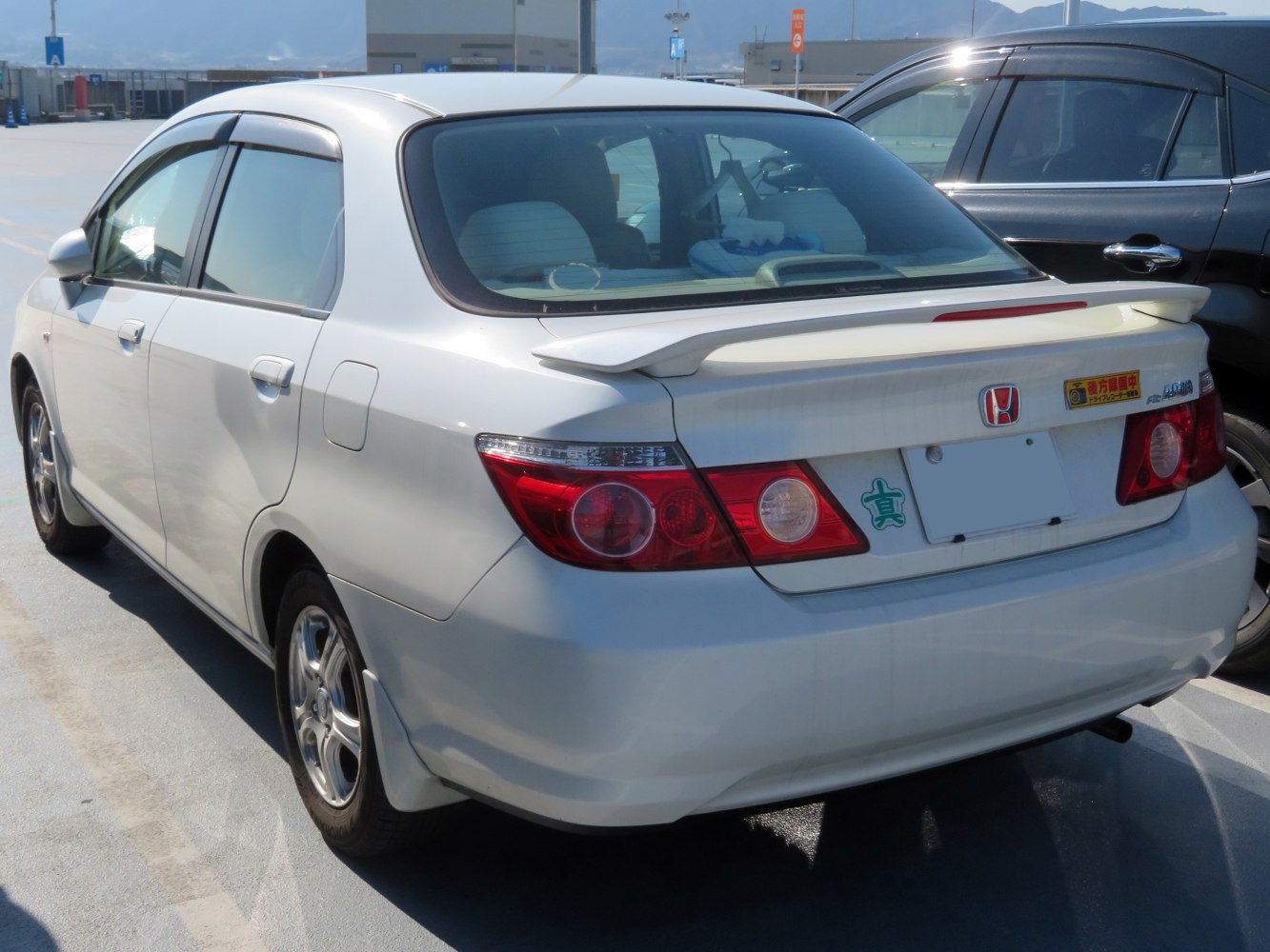 Rear view of compact sedan with rear spoiler and round taillights