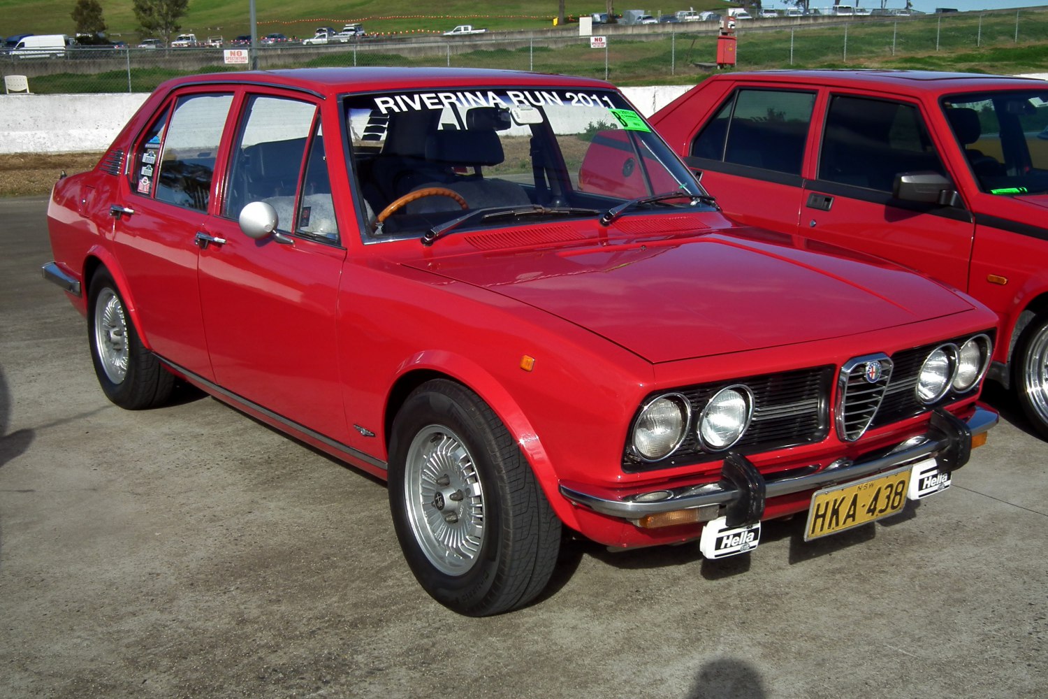 Red vintage sedan with quad headlights and chrome grille