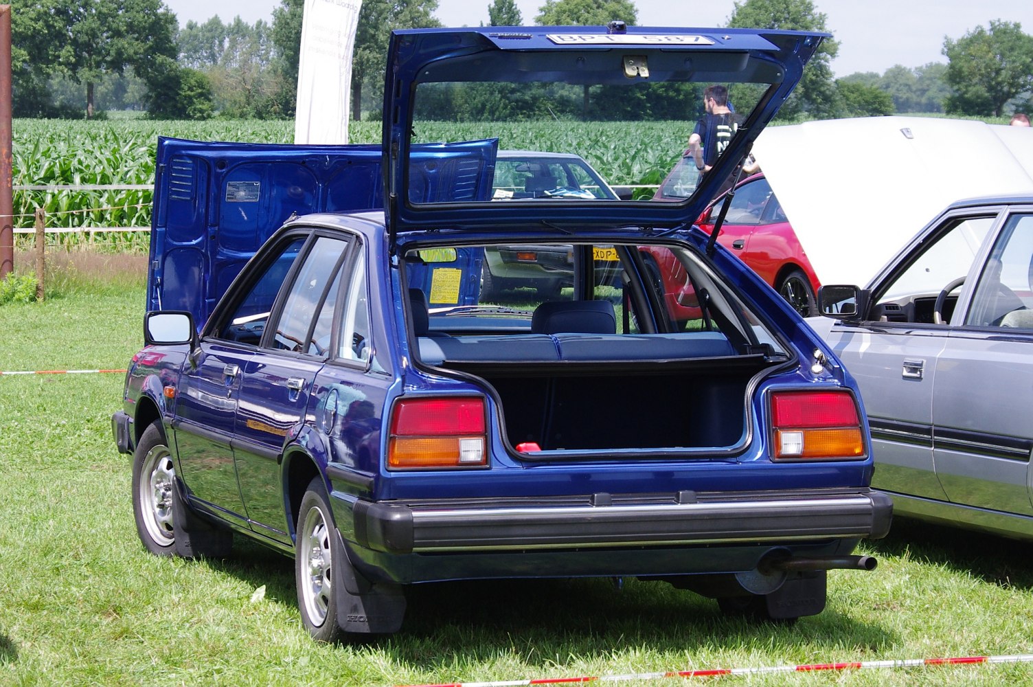 Open rear tailgate of a vintage hatchback with visible interior and rear lights.