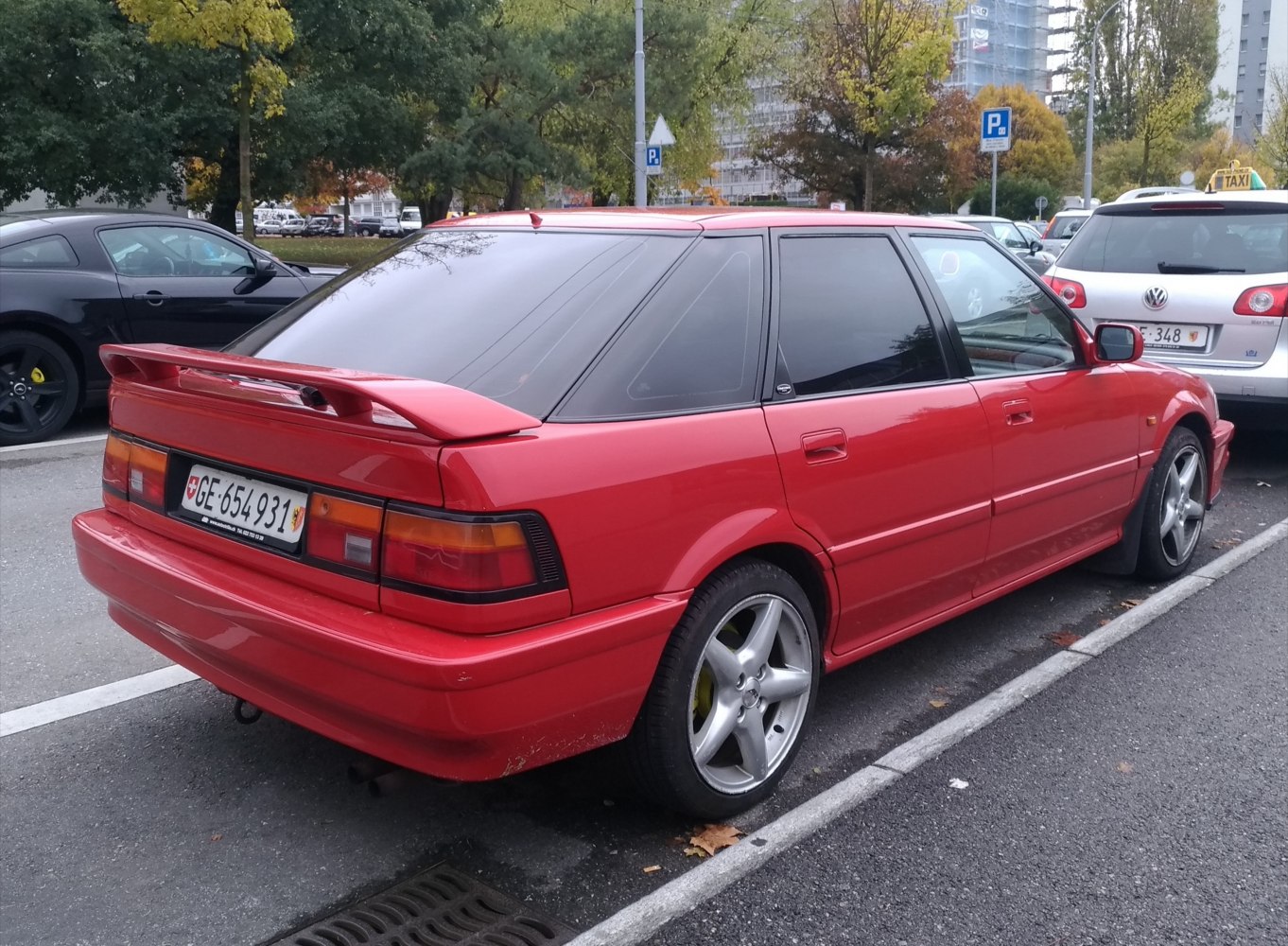 Red hatchback with rear spoiler and alloy wheels