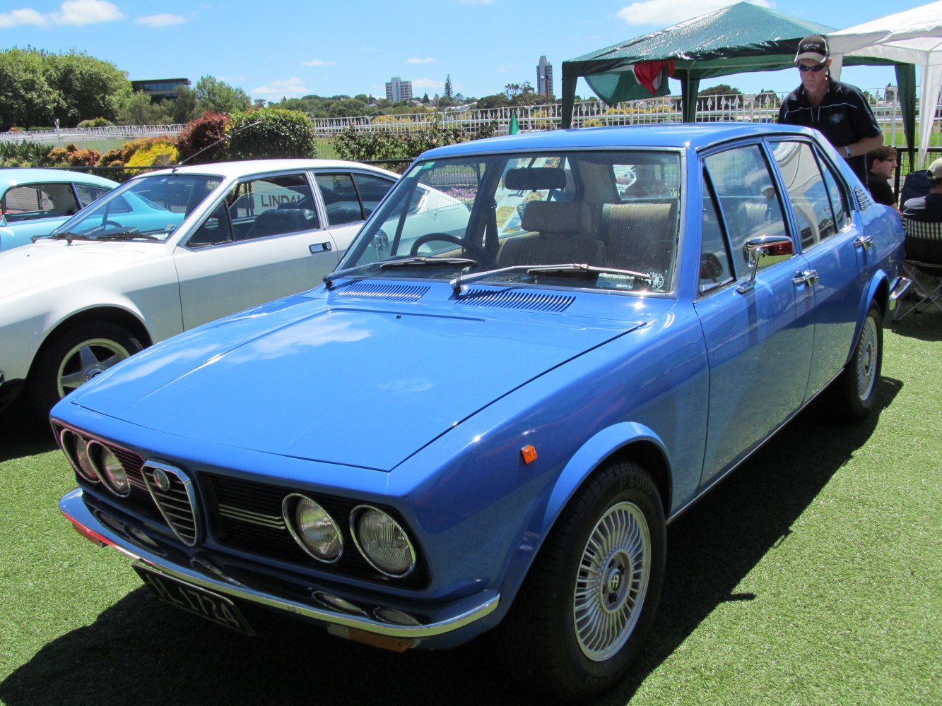 Blue sedan with quad round headlights and alloy wheels