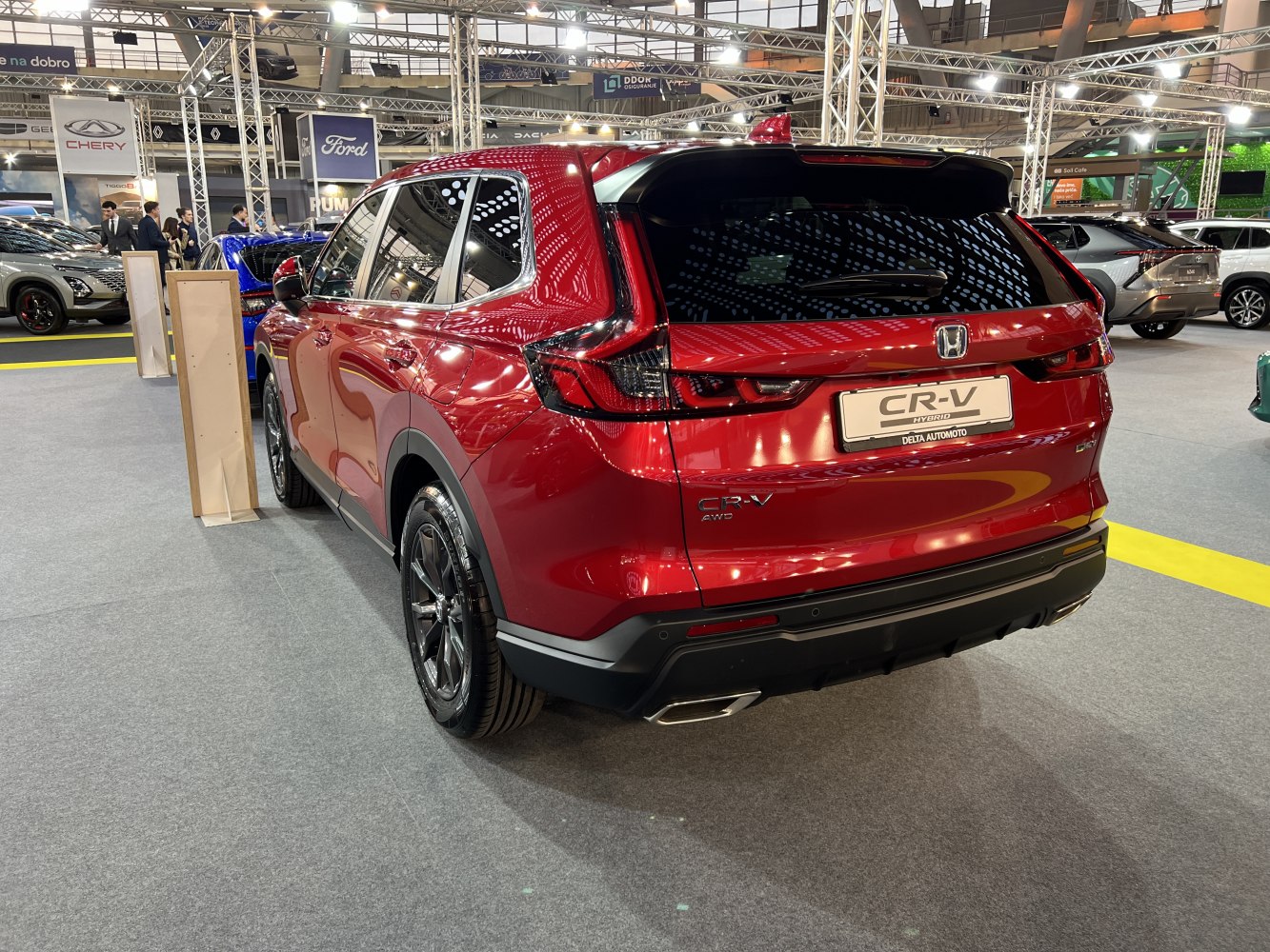 Rear view of a modern red hybrid SUV with sleek taillights and dual exhaust tips.