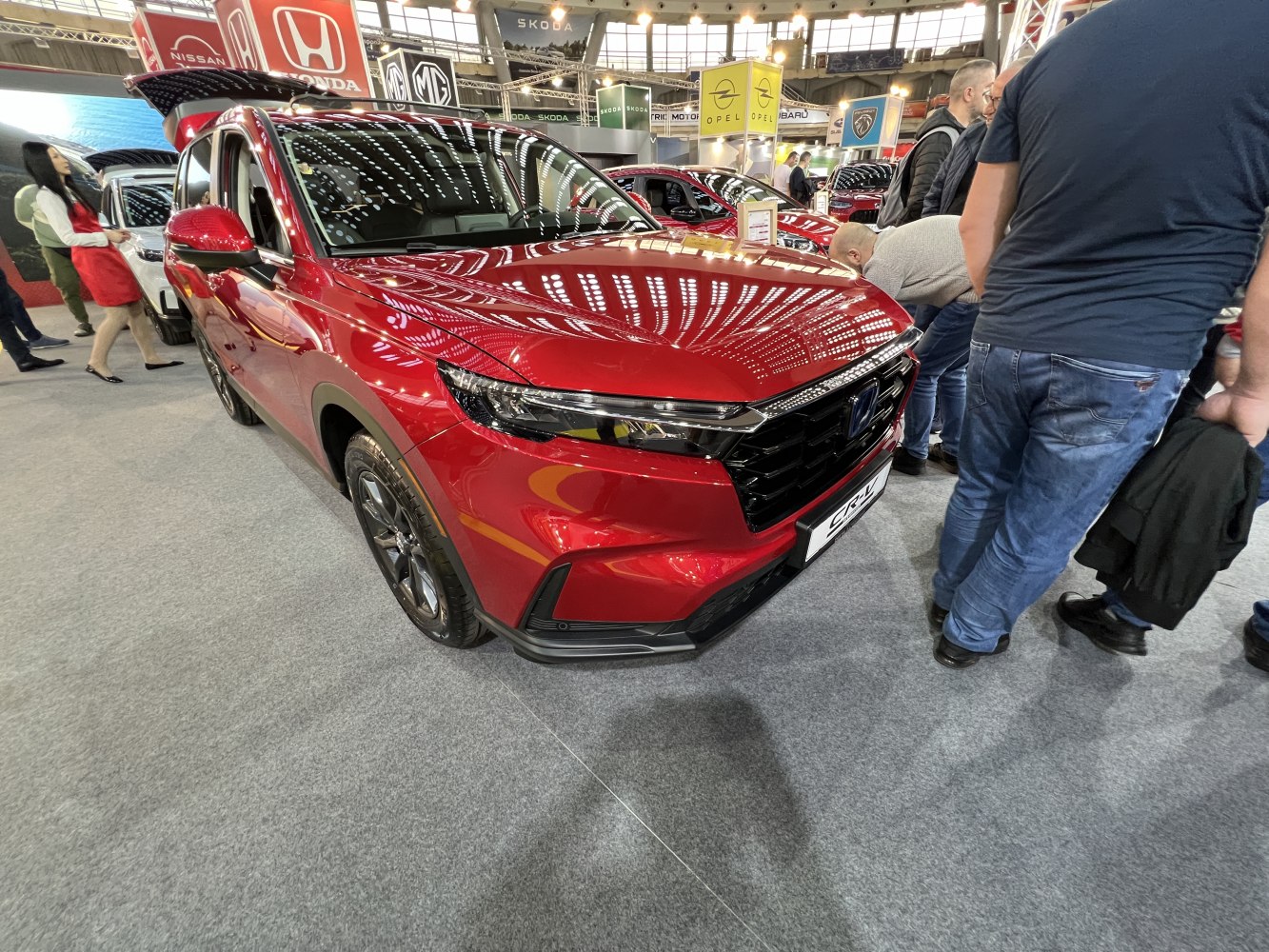 Front section of red SUV with sleek headlights and grille