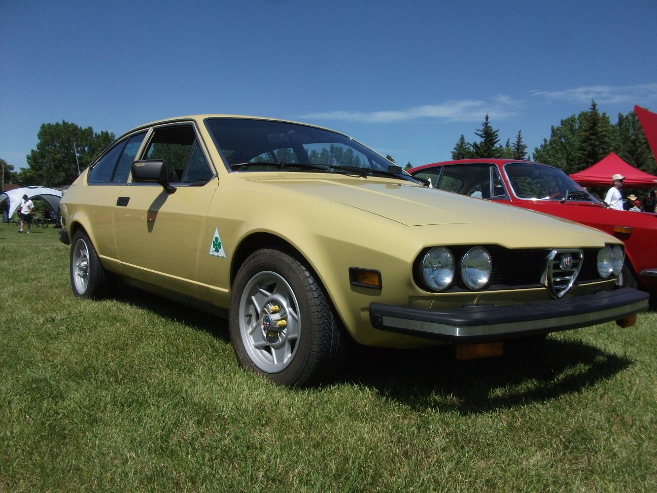 Vintage coupe with quad round headlights, alloy wheels, and sporty emblem.