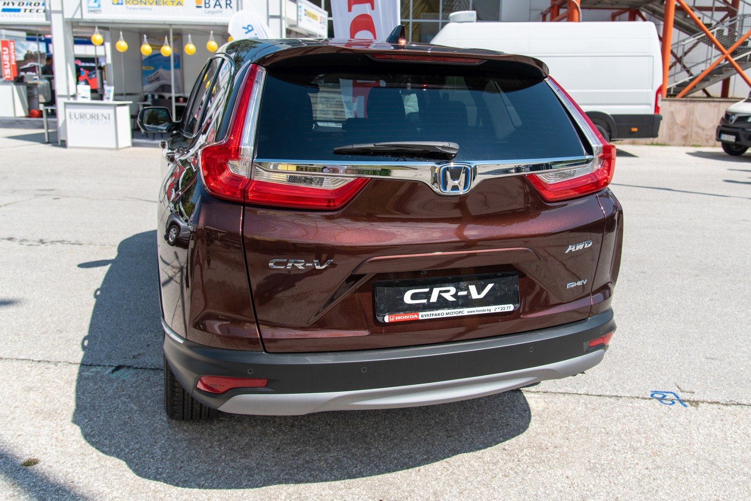 Rear view with AWD and hybrid badges, distinctive vertical tail lights.