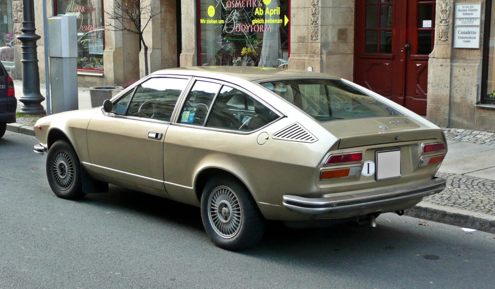 Vintage fastback coupe with louvred rear side panels and round side mirrors
