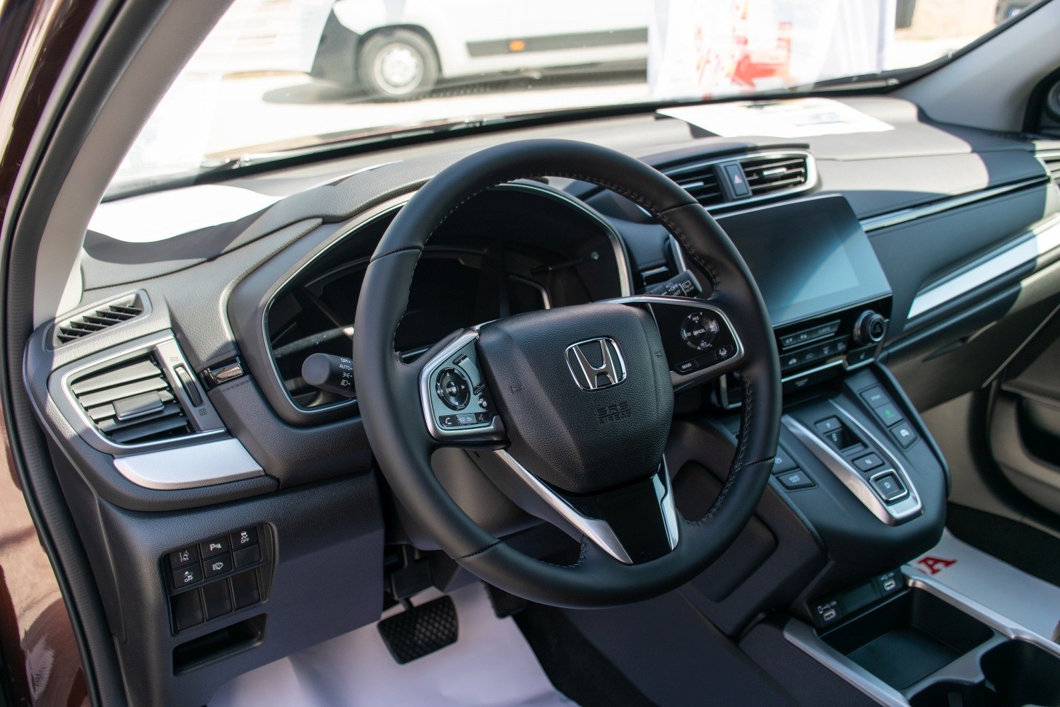 Modern car interior with dashboard, touchscreen, and multifunction steering wheel