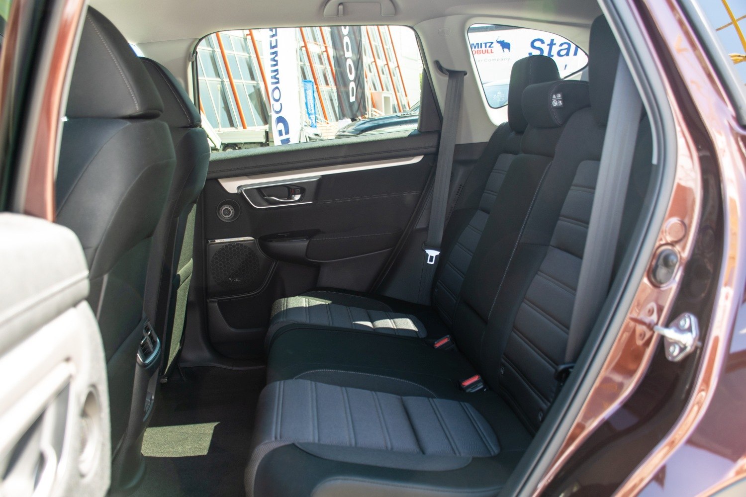 Spacious rear passenger seats with seatbelt and door panel.