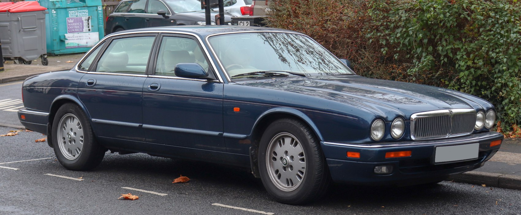 Luxury sedan with quad round headlights and chrome grille in classic design