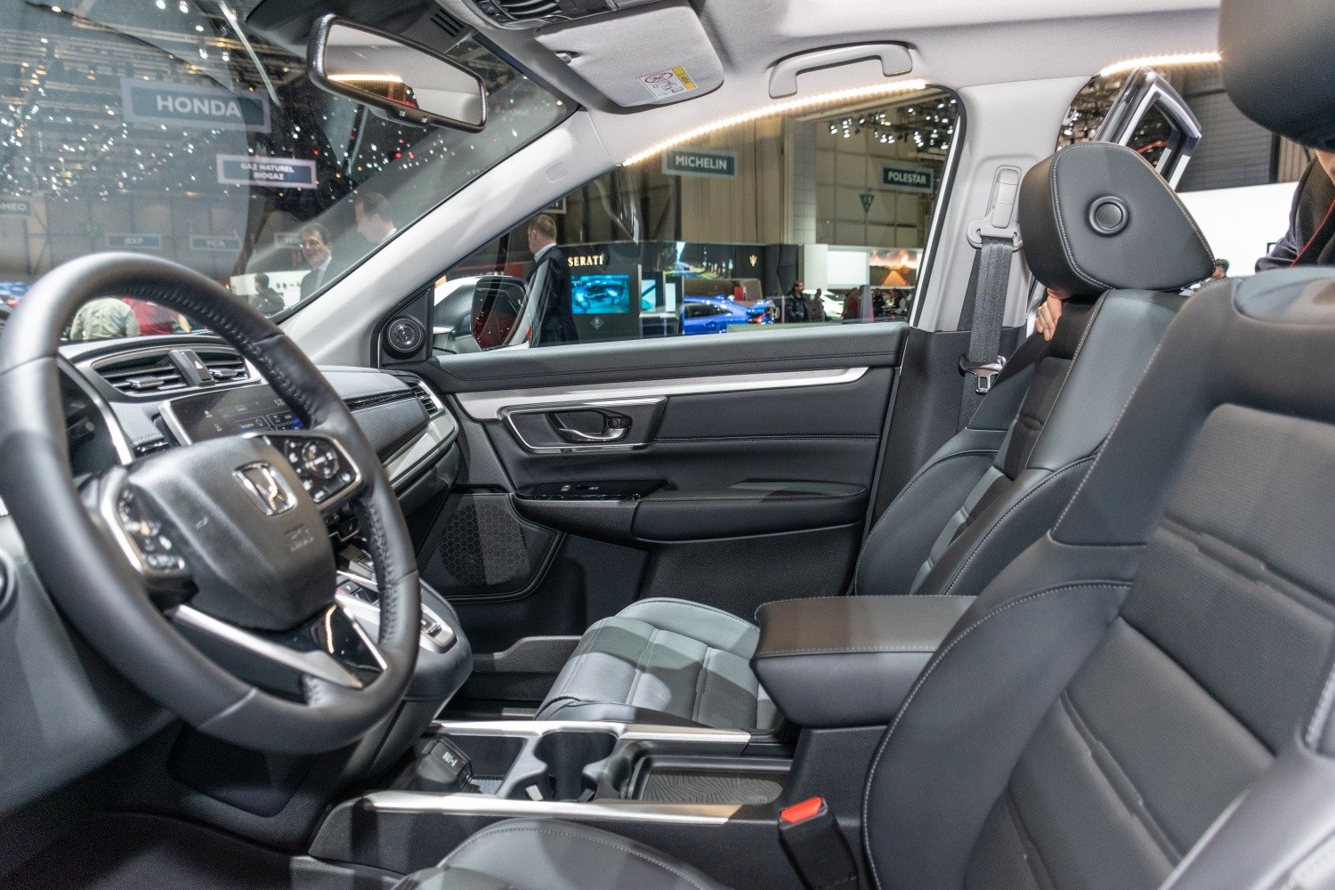 Modern dashboard and leather front seats in car interior.