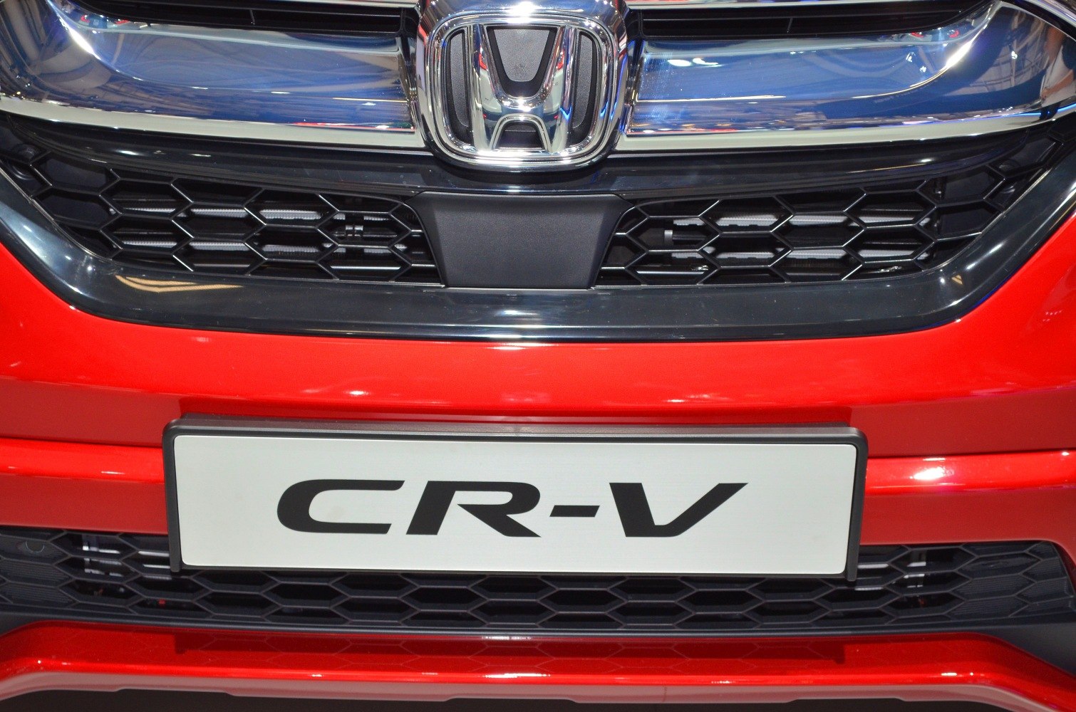 Close-up of front grille and badge on red vehicle