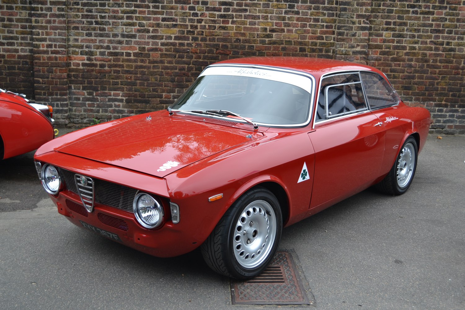 Red classic coupe showing front angled view with round headlights