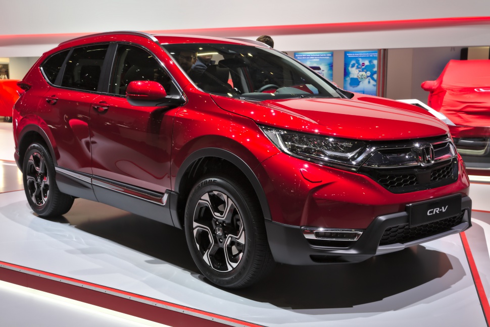 Front angled red SUV with sleek headlights and alloy wheels