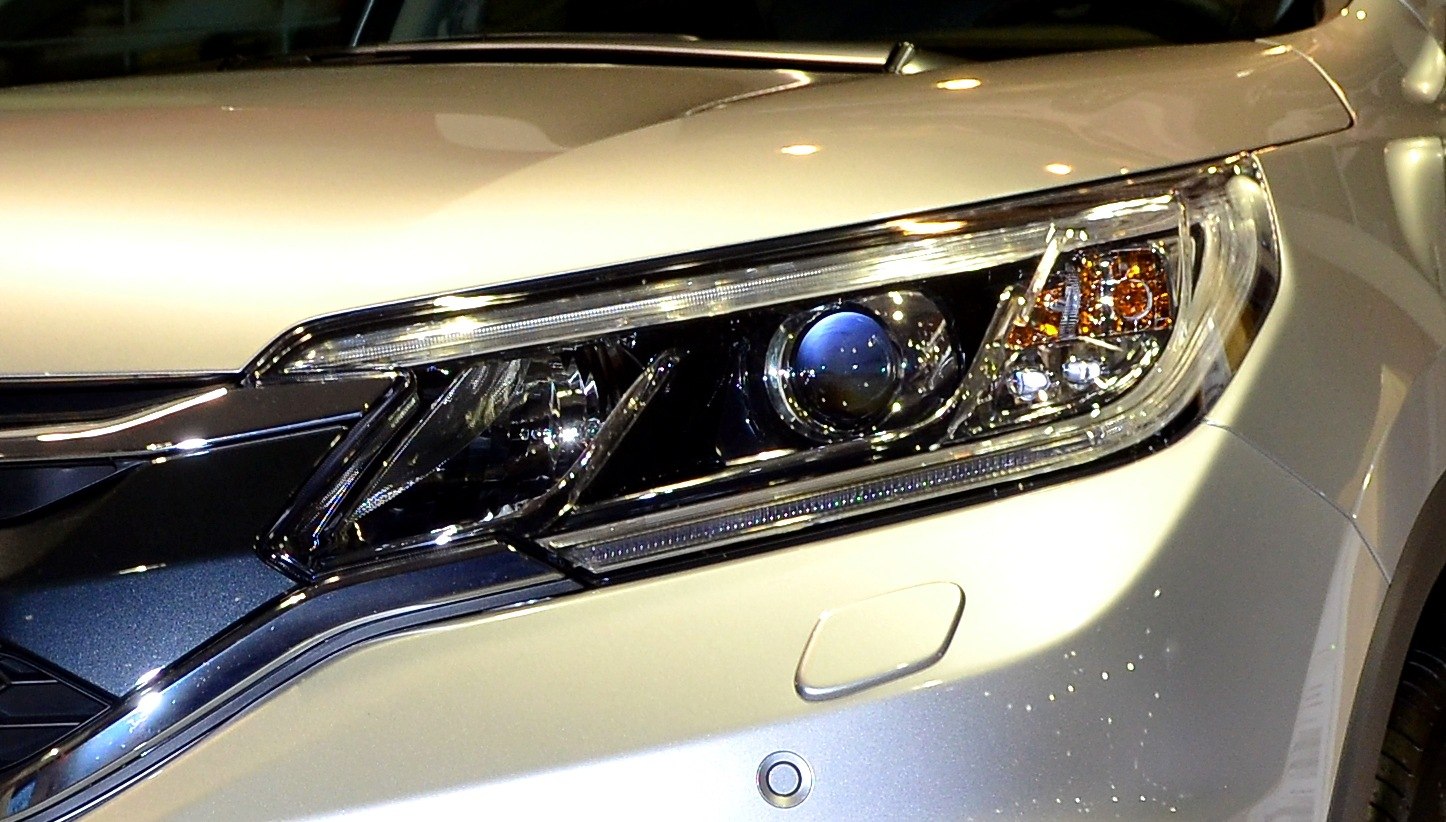 Close-up of a modern projector headlight with LED and chrome trim.