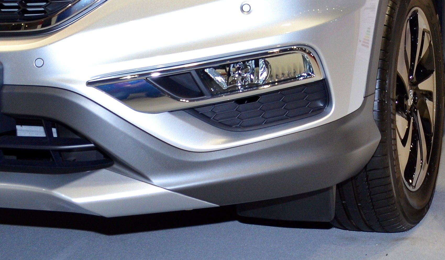 Front bumper with integrated fog light and alloy wheel with tire