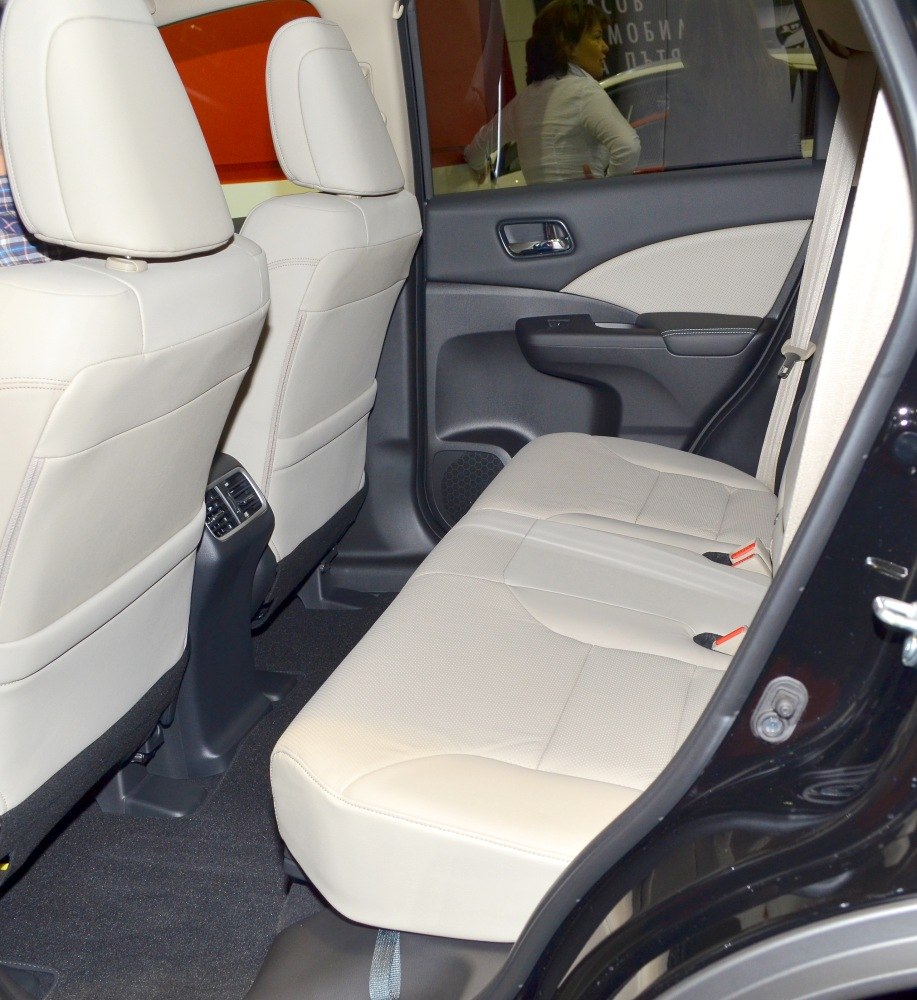 Rear beige leather seats with rear air vents and door panel.