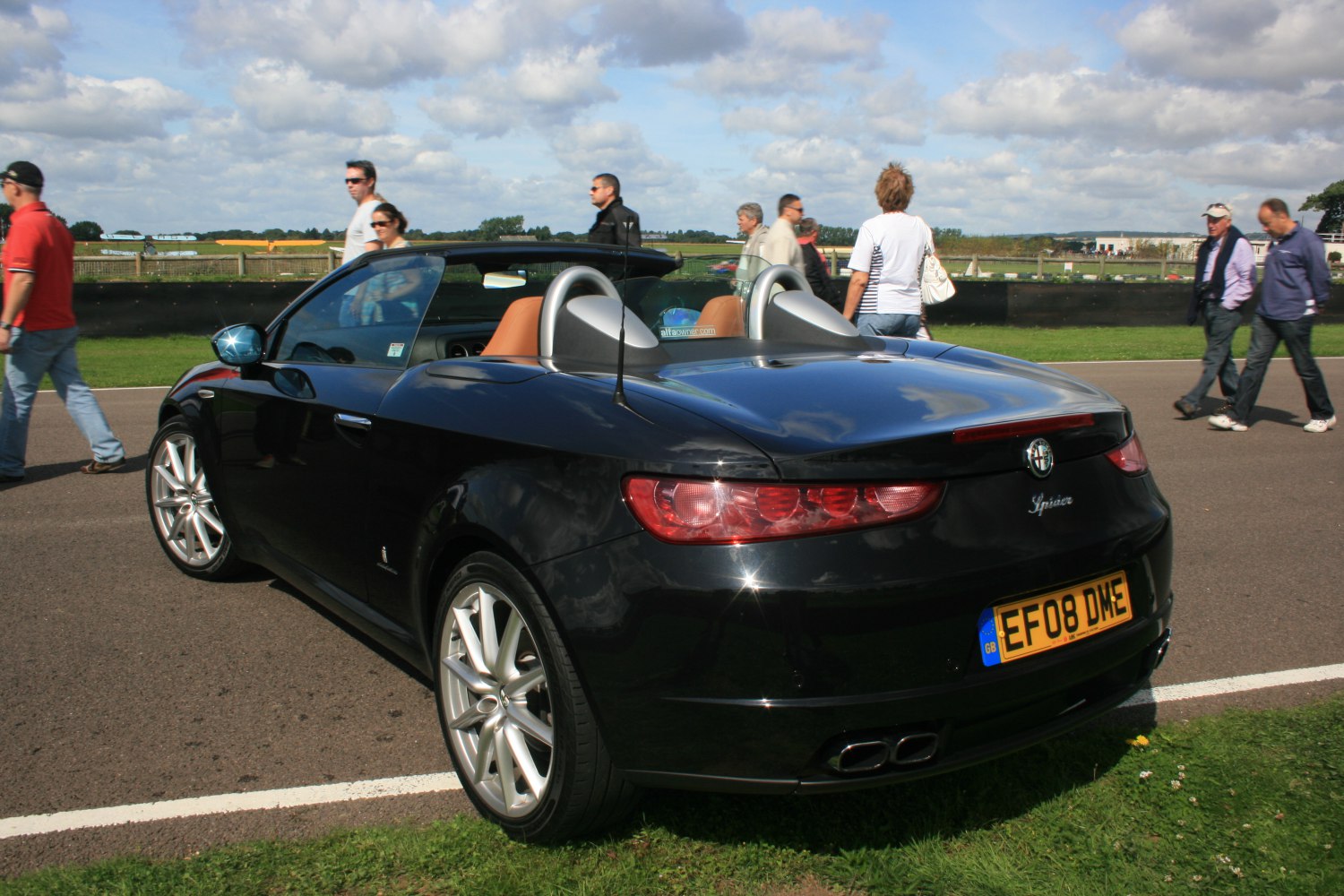 Rear-side view of a convertible with distinctive taillights and dual exhaust