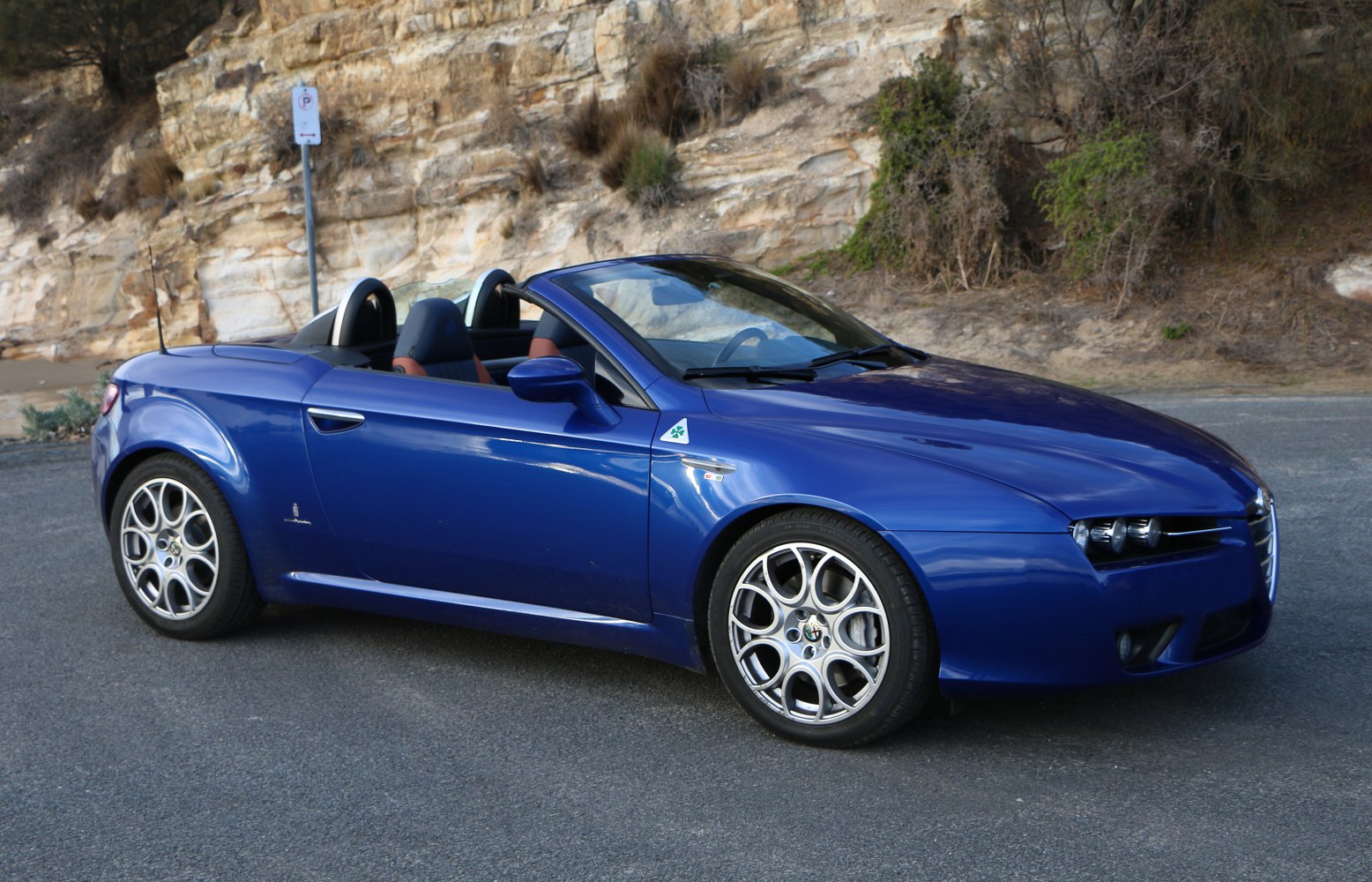 Blue convertible sports roadster with distinctive headlights and alloy wheels